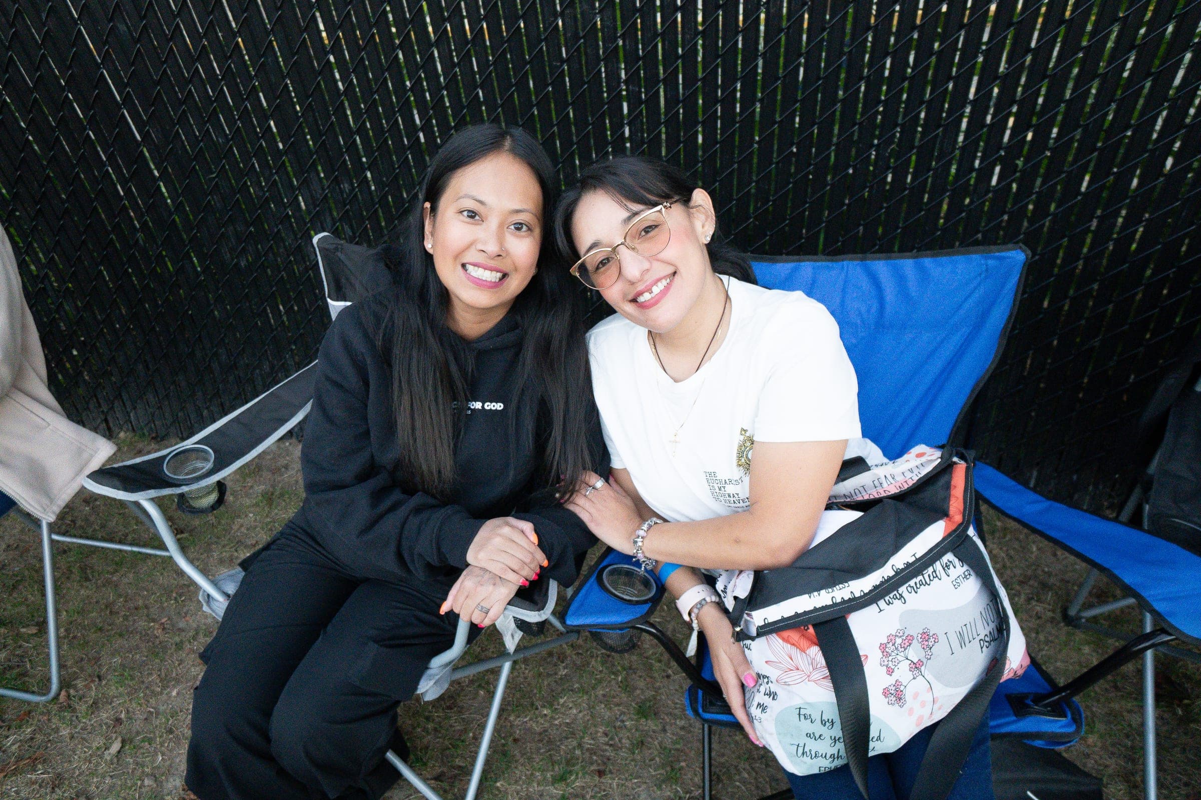Two friends in a camping chair at the back