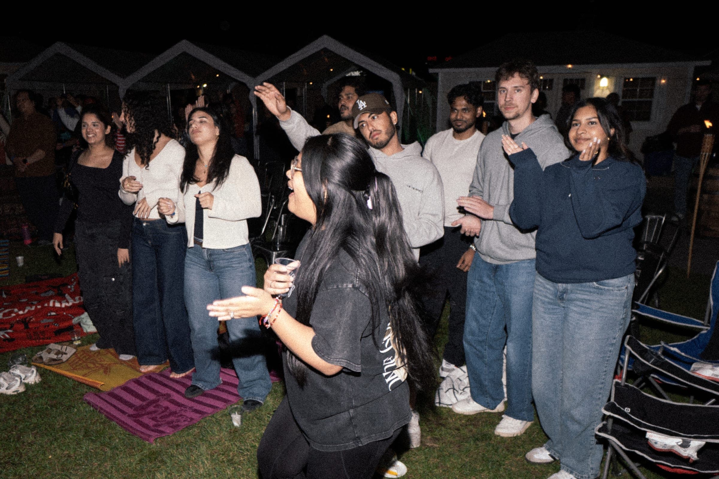 Young adults together under string lights at a WITHIN gathering