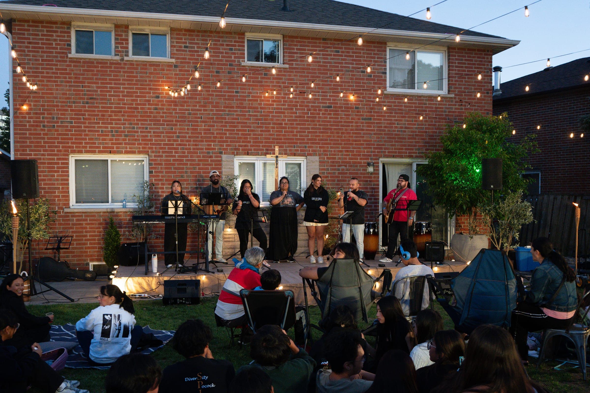 The band on the patio with the crowd out on the grass