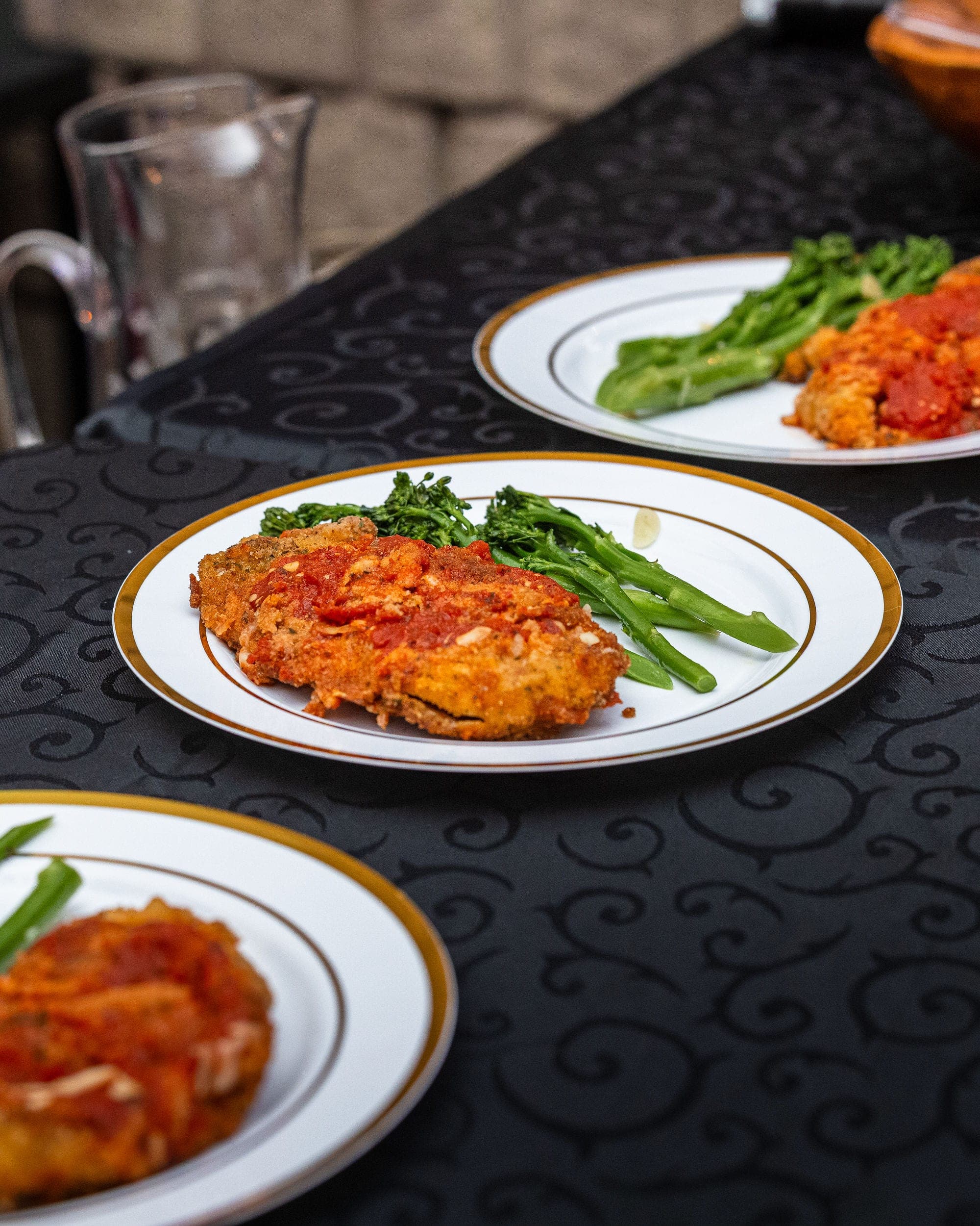 Chicken parmigiana and broccolini, plated