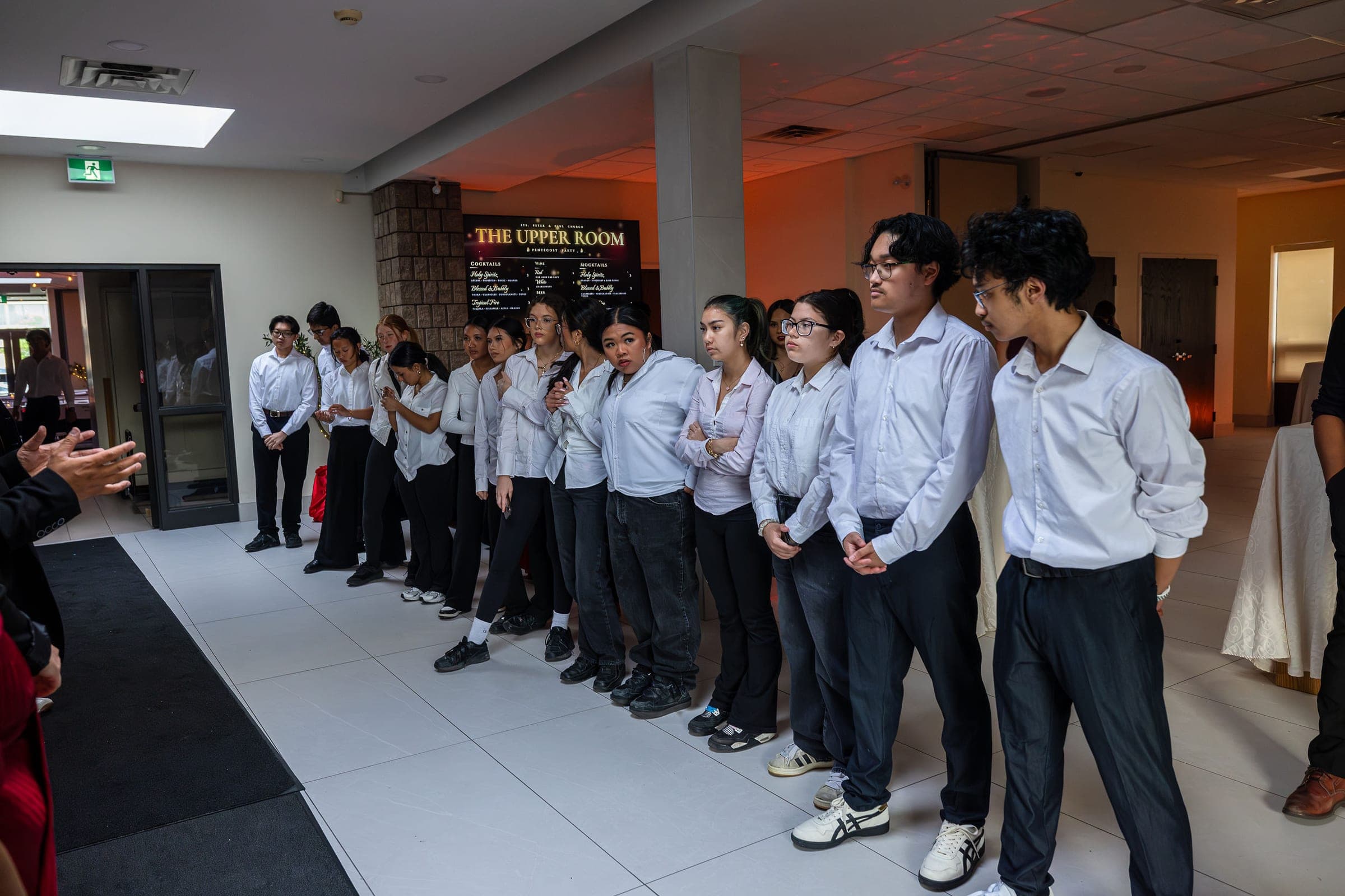 The service team lined up in the lobby under the Upper Room board before the doors opened